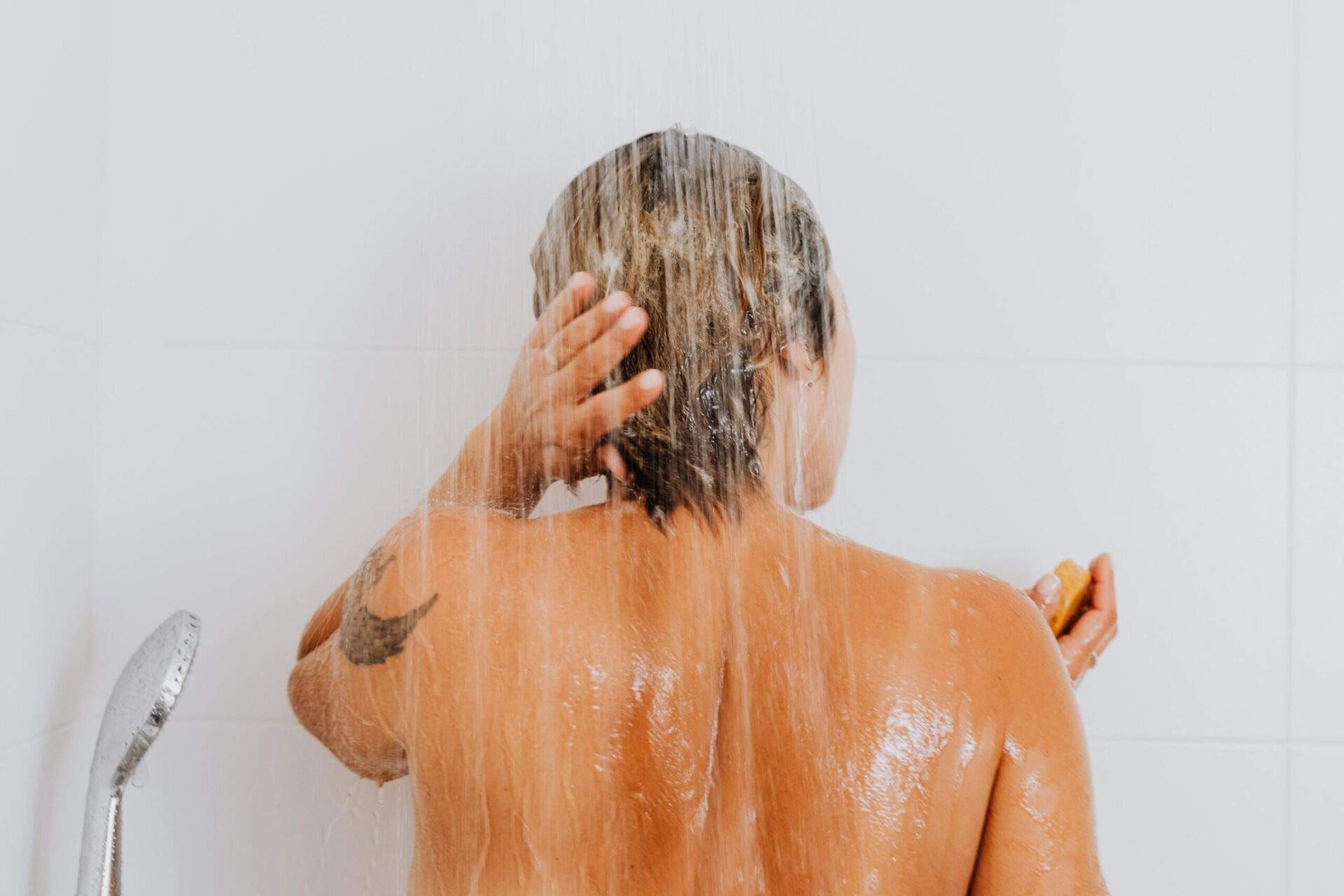 woman washing her hair with vegan shampoo