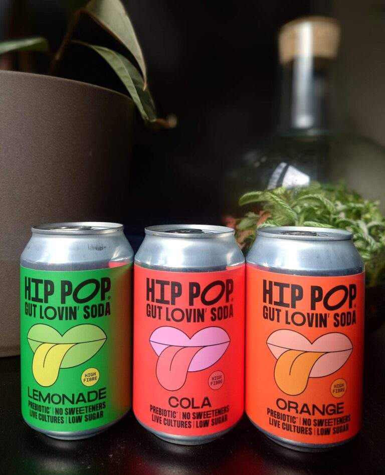 Three Hip Pop drinks all in a row. They look like a beverage rainbow in many different colours. In the background, you can see plants and a terrarium.