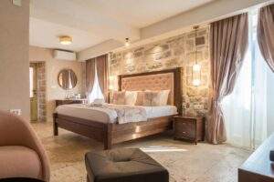 A luxurious double bed in a vegan-friendly hotel bedroom with stone walls and tasteful decor